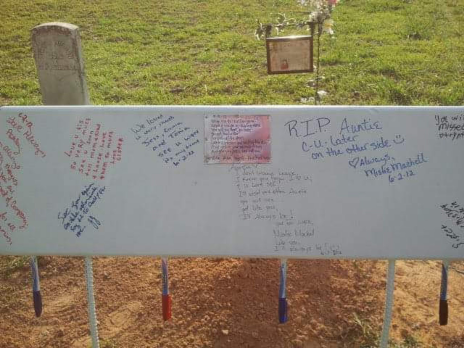 Close view of handwritten memorial messages and hanging markers.