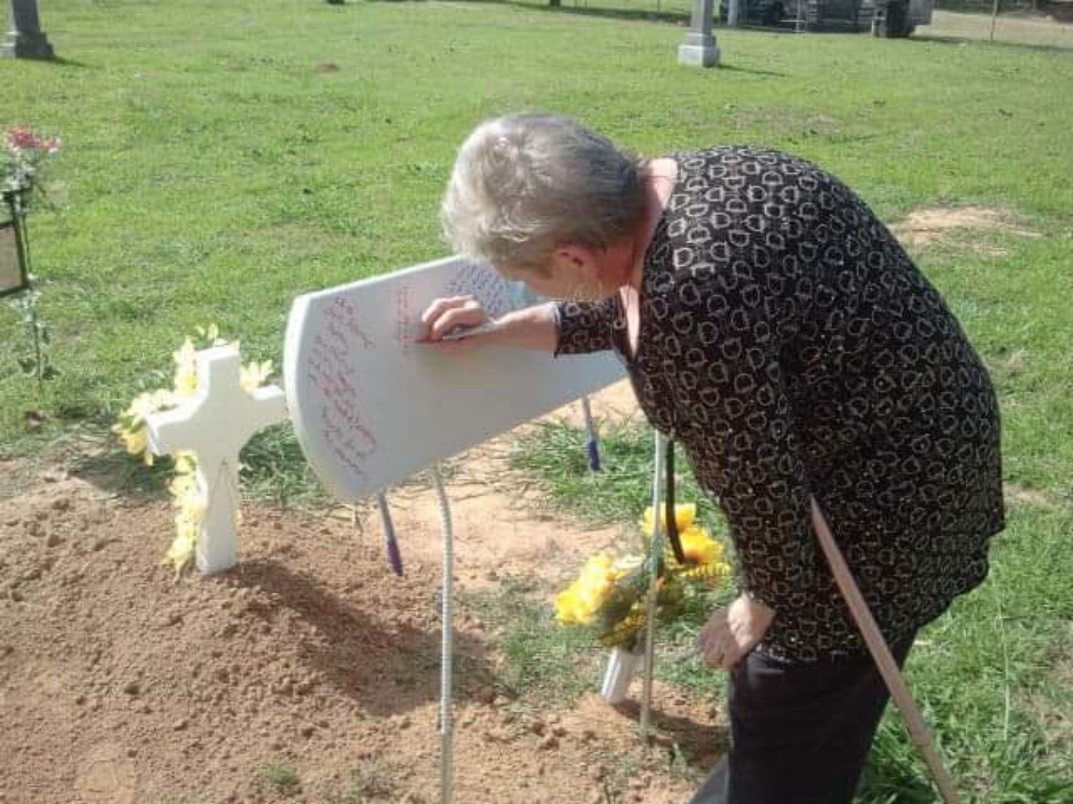 Woman writing a personal message on the Signing Stone.